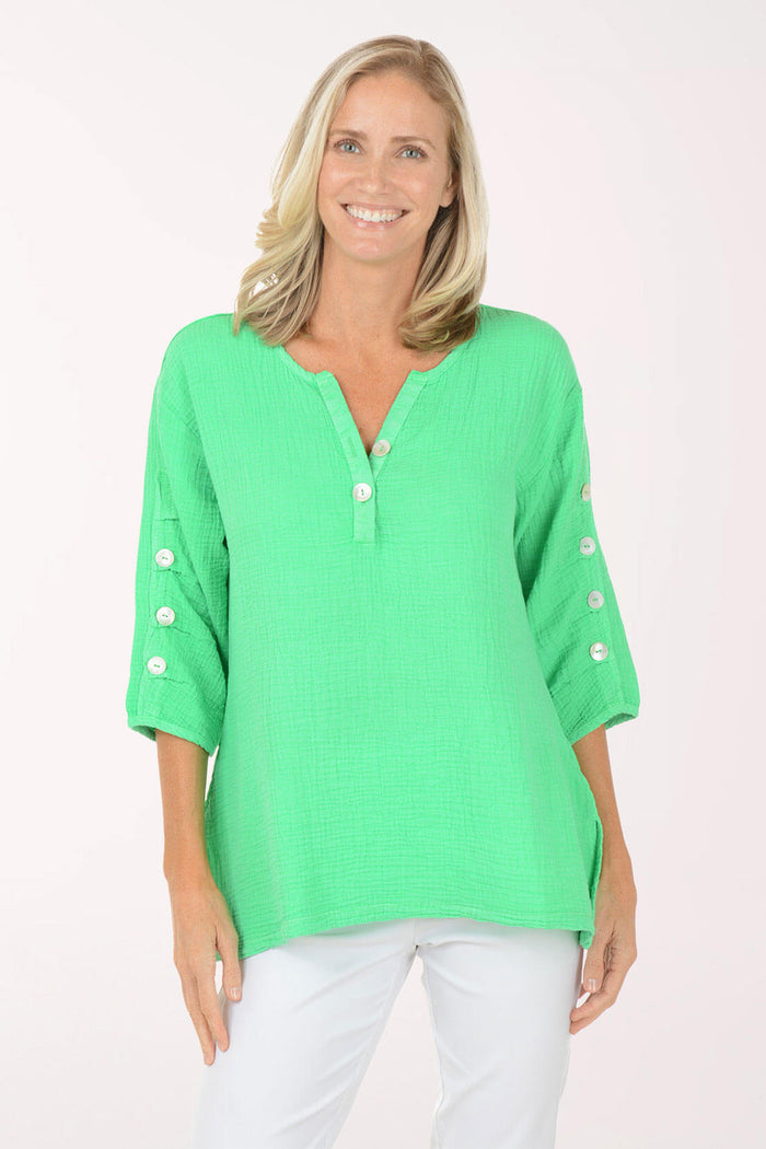 Woman wearing a green blouse with white buttons on a white background