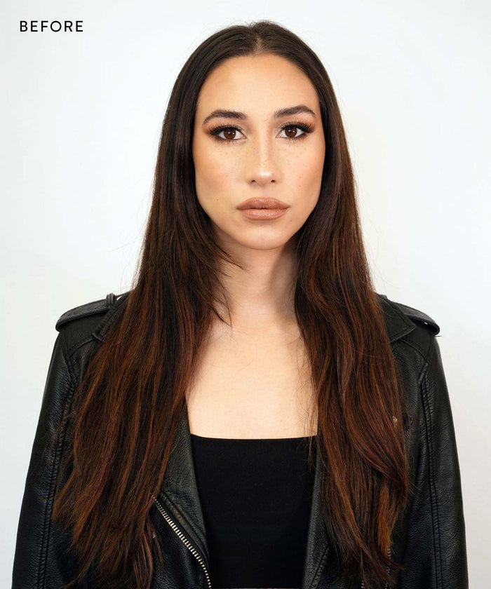 A woman with long straight brown hair wears Perfect Locks Clip-In Bangs, a black leather jacket, and a black top, standing against a plain white background. "BEFORE" appears in the top left corner.