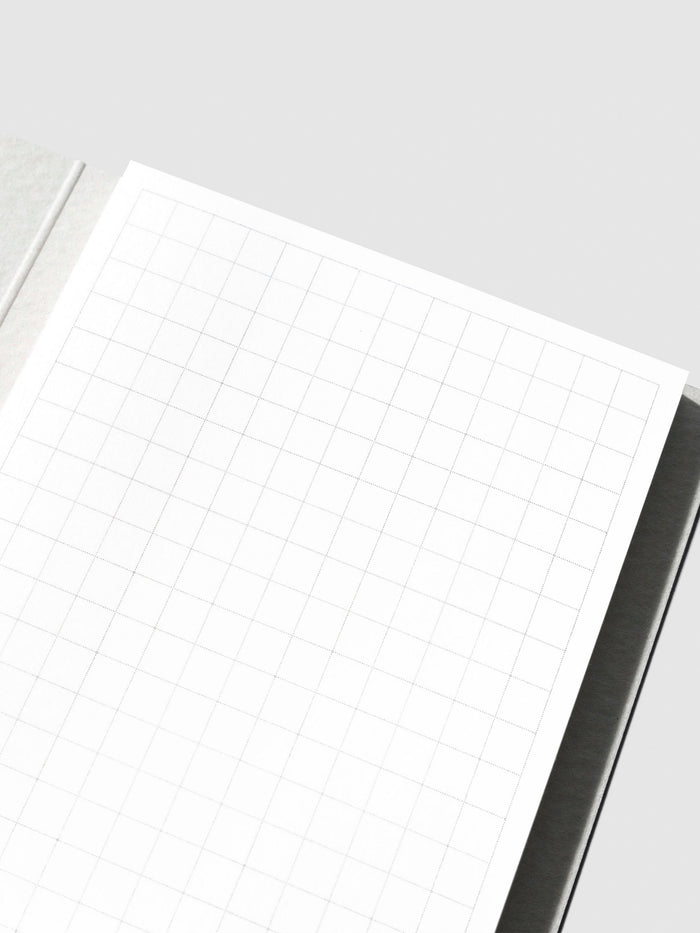 Closeup of sticky note in its packaging displayed on a neutral background.