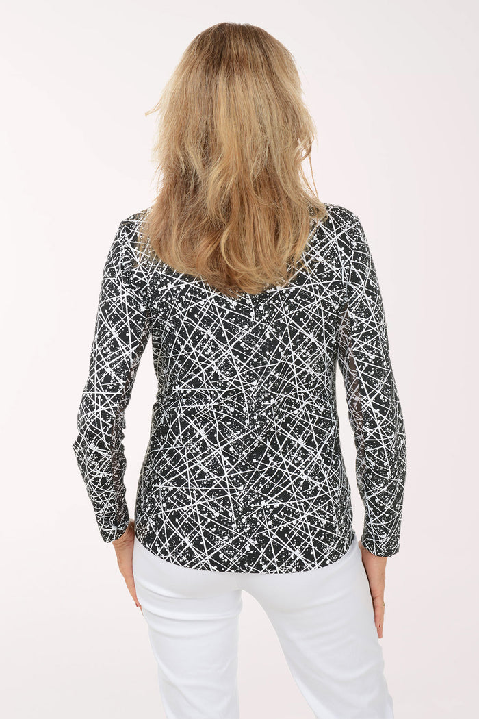 Woman wearing a black and white patterned long-sleeve top on a white background