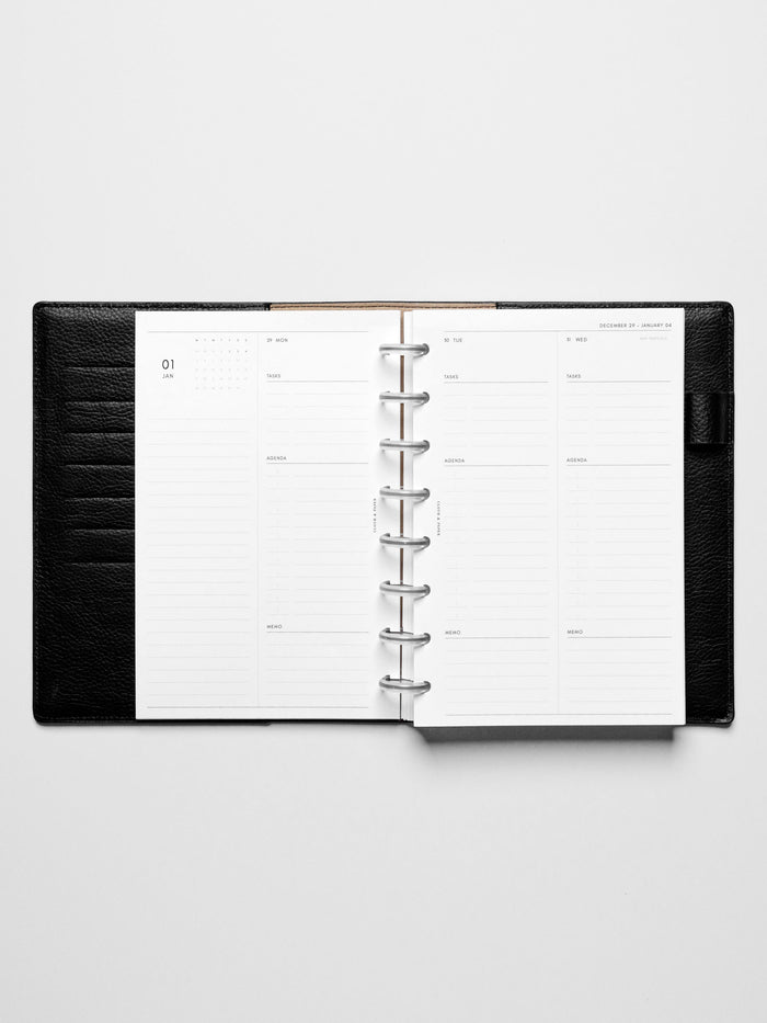 Image shows the Monday Start 2026 Dated Daily Planner Insert in a black leather disc-bound planner.