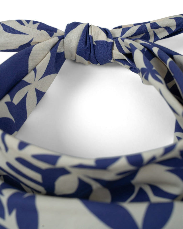 Close-up of the Saltrock Balance Bandana in blue, crafted from 100% cotton with a blue and white leafy pattern. Square cut and tied neatly.