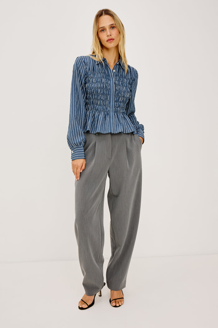 Bradshaw Shirt in Cotton Poplin With Button-Up Front, Collar, Smocked Body, Peplum Hem, and Bishop Sleeves in Washed Indigo Stripe Colorway - Full Body Front View Featured on Model