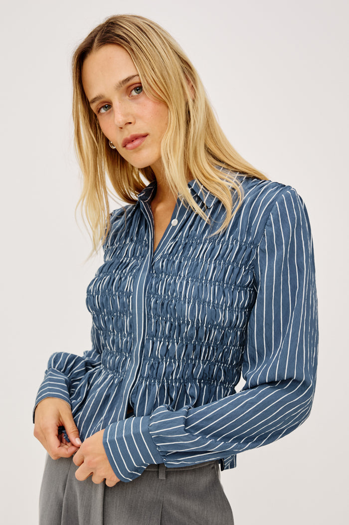 Bradshaw Shirt in Cotton Poplin With Button-Up Front, Collar, Smocked Body, Peplum Hem, and Bishop Sleeves in Washed Indigo Stripe Colorway - Upper Body Front View Featured on Model