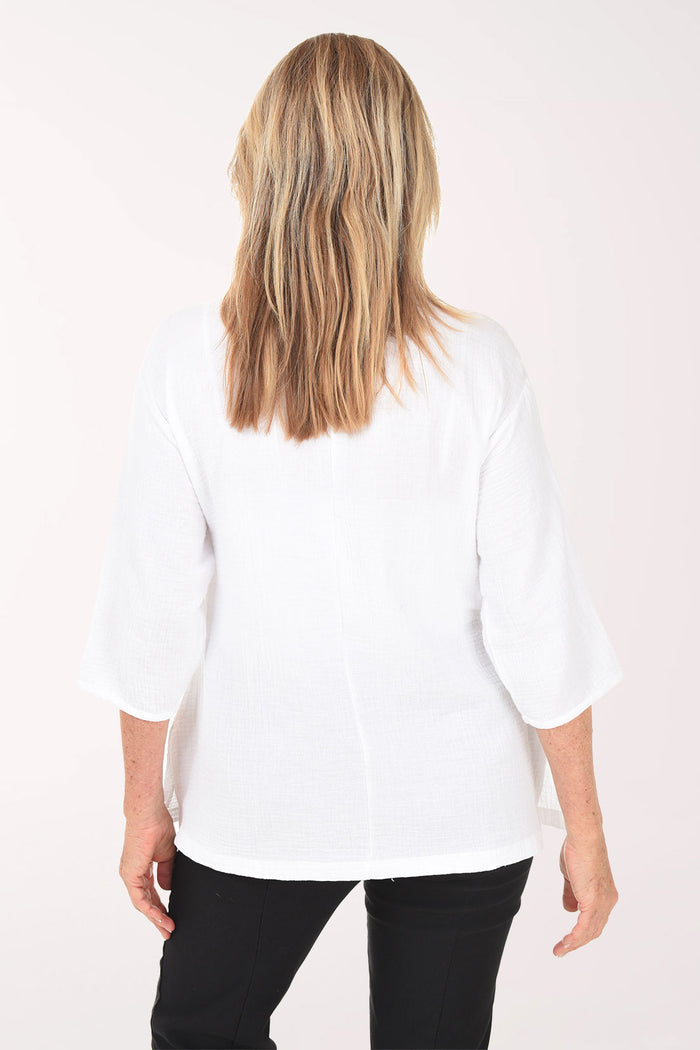 Woman wearing a white blouse with a plain background