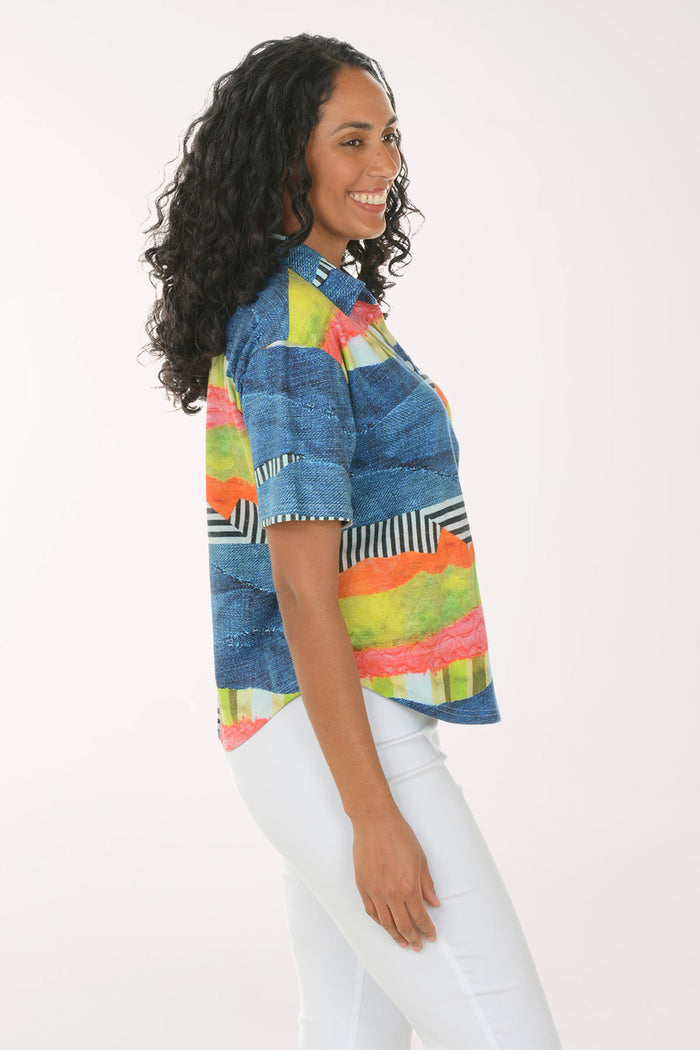 Woman wearing a colorful striped shirt and white pants on a white background