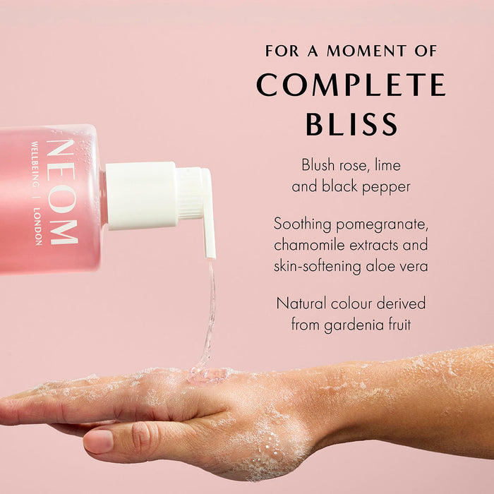 NEOM Complete Bliss hand wash pouring onto hand with ingredient details including rose, lime, and black pepper