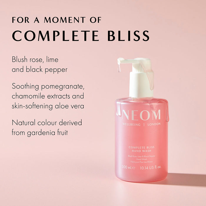 NEOM Complete Bliss hand wash bottle with ingredients including blush rose, lime, black pepper, and aloe vera on pink background