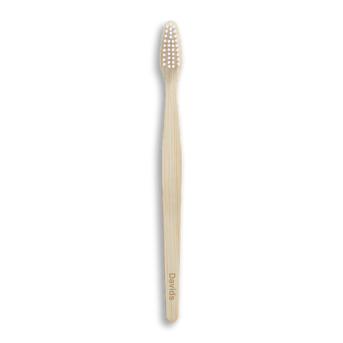 Bamboo toothbrush with white bristles on black background