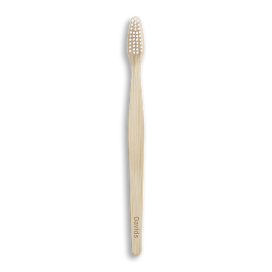 Bamboo toothbrush with white bristles on black background