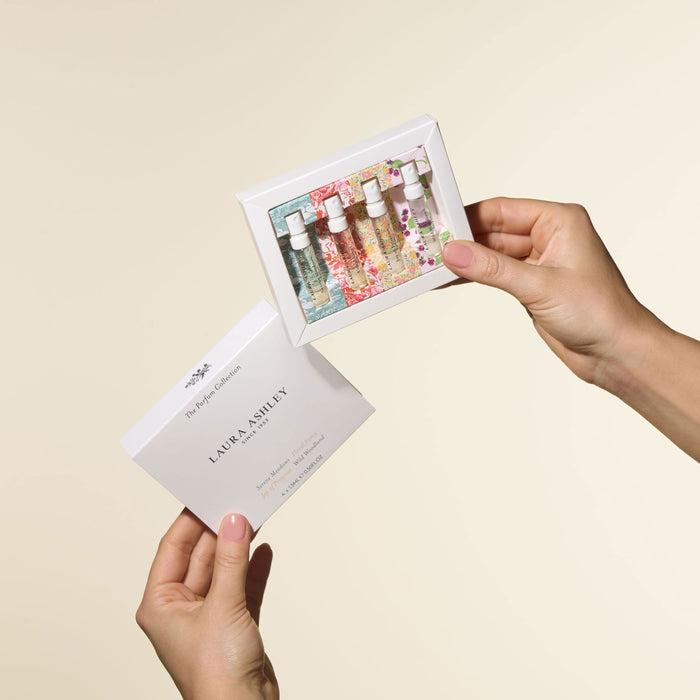 Laura Ashley perfume collection in hands on a beige background