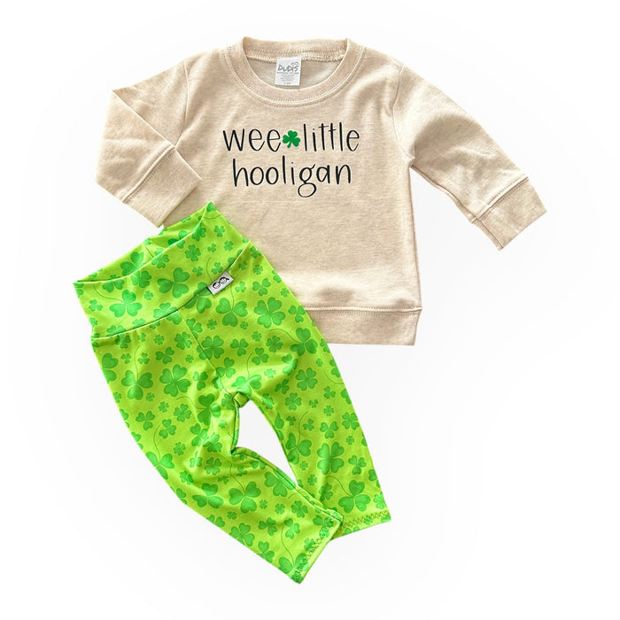 Adorable St. Patrick's Day outfit for babies and toddlers, featuring a 'Wee Little Hooligan' beige pullover paired with bright green shamrock leggings. Perfect for festive celebrations or everyday wear.