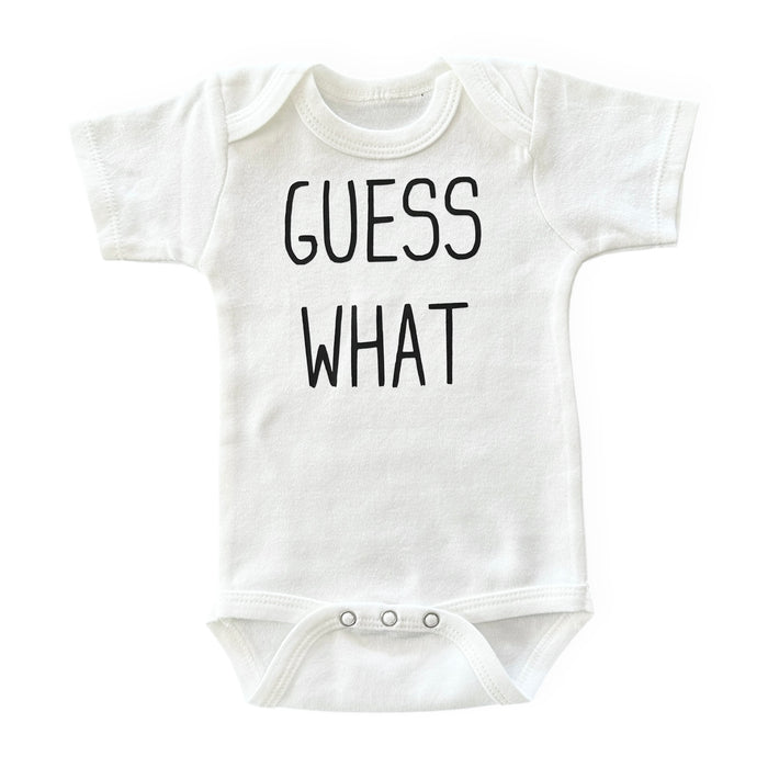 White baby bodysuit with "Guess What?" text – soft, breathable, and perfect for newborn photoshoots.
