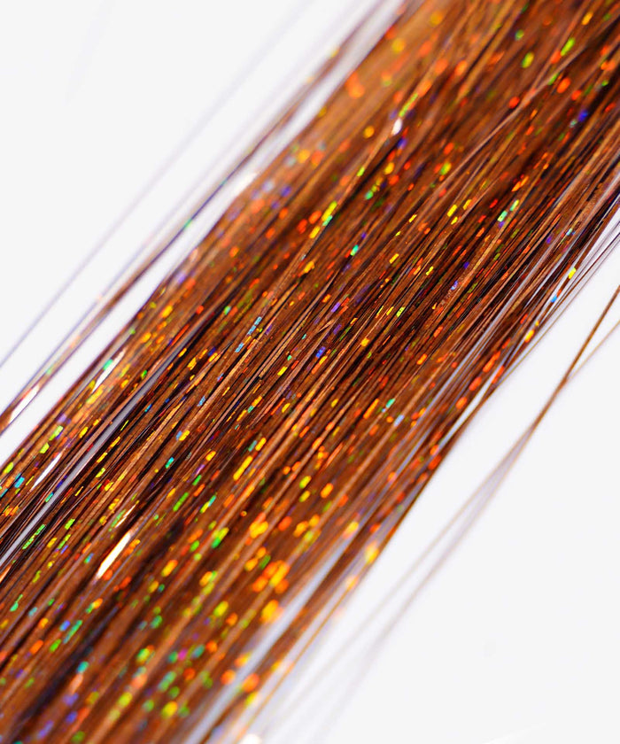 Close-up of Perfect Locks' Perfect Hair Tinsel in Unicorn color, with shiny, multicolored strands creating a sparkling, festive look against a white background.#color_rust