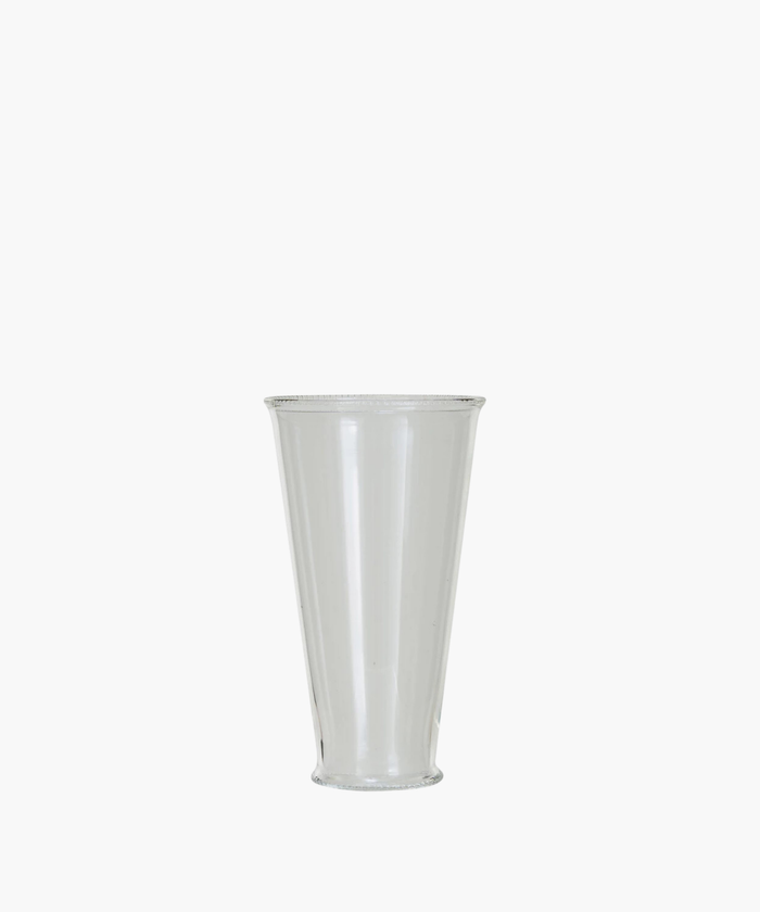 A clear, cylindrical drinking glass with a slightly flared rim. The simple design and transparent material create an elegant and minimalist appearance. | SW Home