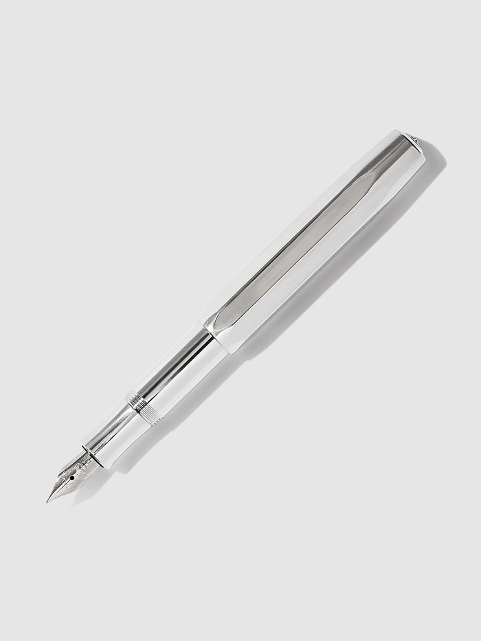 Kaweco AL Sport Fountain Pen, Raw Aluminum, Cloth and Paper. Raw Aluminum Kaweco pen displayed on a neutral background. The pen's nib is exposed.
