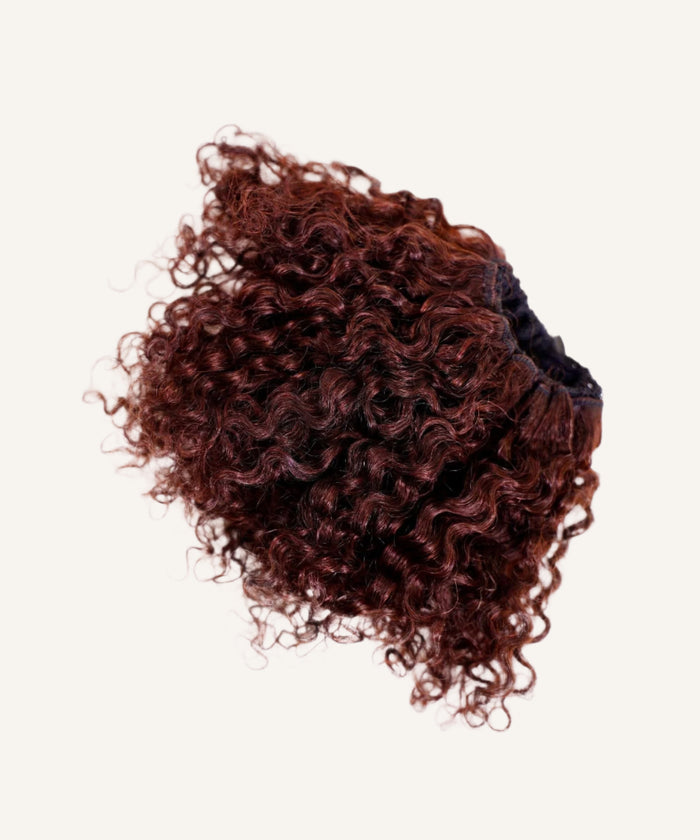 The Perfect Locks Kinky Curly Clip-In Bun in Burgundy  against a light background, with tight, voluminous curls and a fluffy, rounded look.#color_burgundy-(99J)