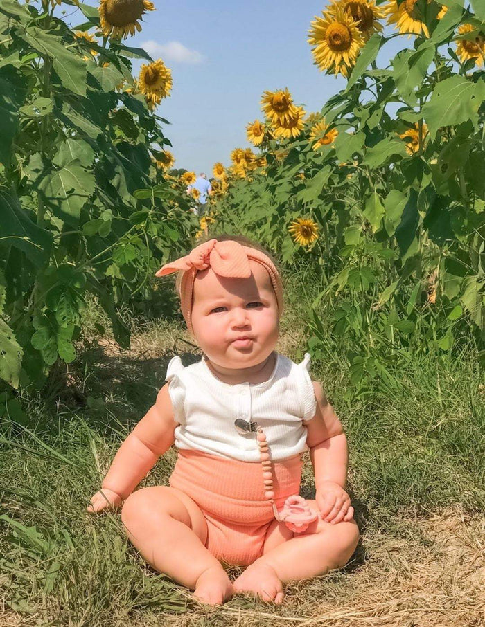 Baby Girl in Melon Ribbed Headband in field of sunflowers