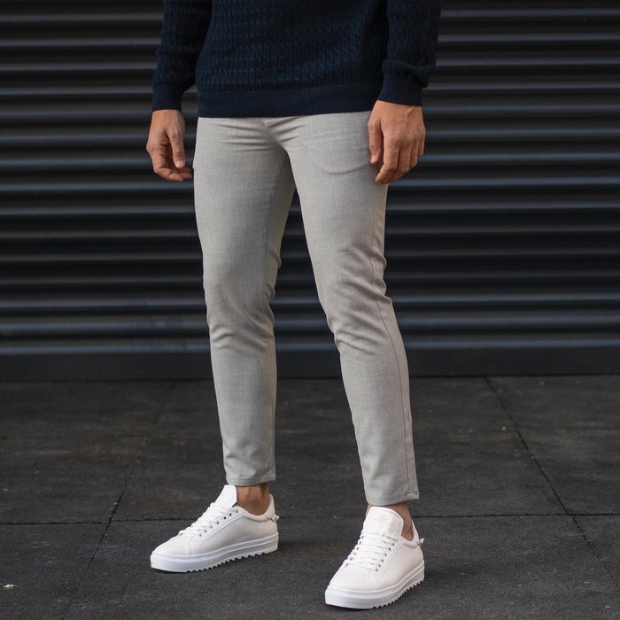 Martin Valen men's gray trousers, front-side view on model, light-gray with subtle knee creasing and hem above the ankle