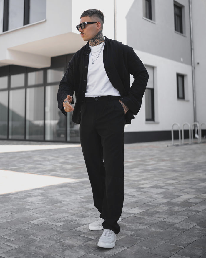 Martin Valen men's oversized loose-fit black sports pants, full-length side view walking showing high waist and relaxed fit