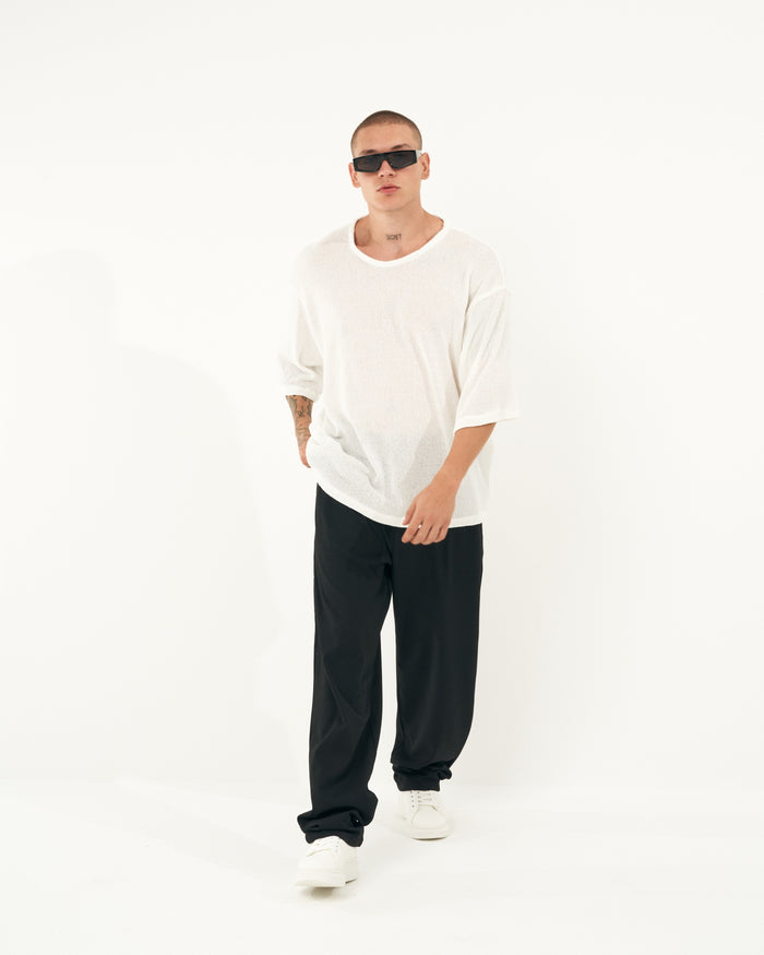 Martin Valen men's oversized loose-fit black sports pants, three-quarter front view with long hem visible