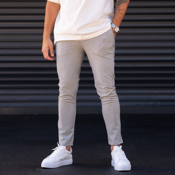 Martin Valen men's slim-fit lycra gray slacks, front mid-body view with right hand in pocket and white sneakers visible