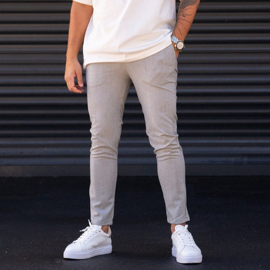 Martin Valen men's slim-fit lycra gray slacks, front mid-body view with right hand in pocket and white sneakers visible