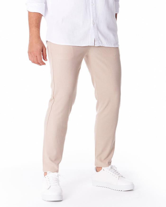 Martin Valen men's light beige trousers in lightweight fabric, full side view showing straight leg, ankle hem and white sneakers visible