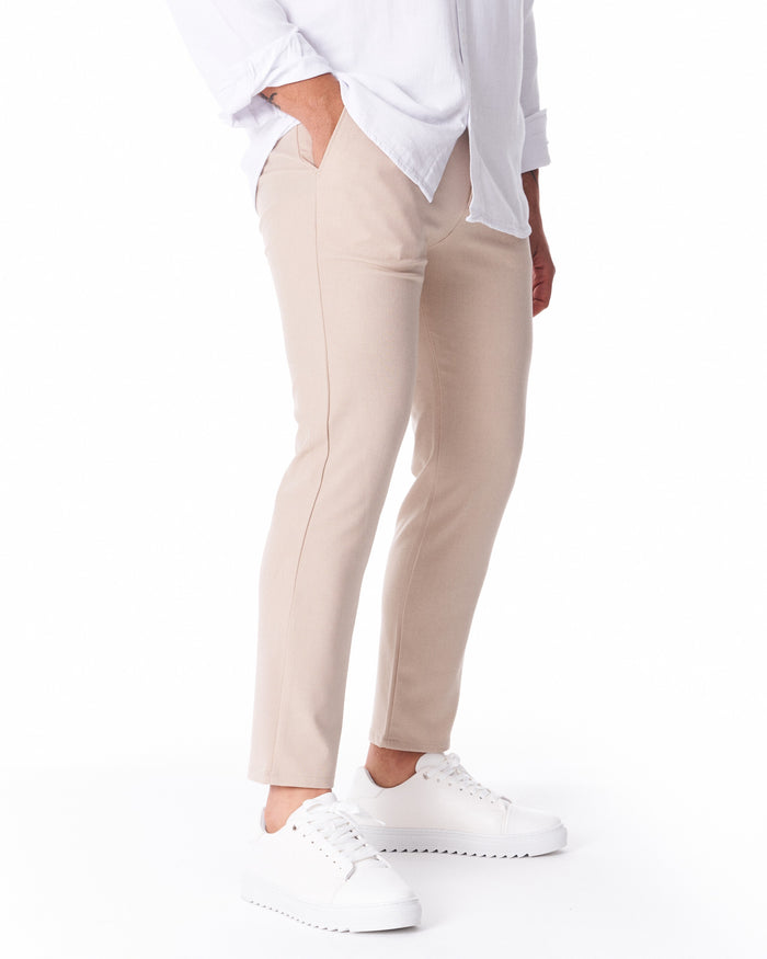 Martin Valen men's beige light-fabric trousers, rear mid-leg view showing a subtle front pocket and straight cut