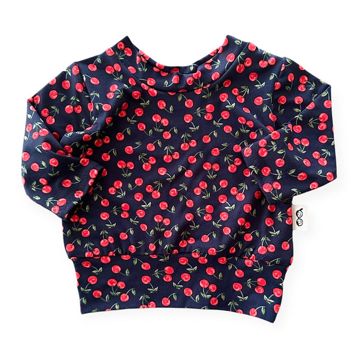 Cute and comfy baby sweatshirt – Midnight Cherries pullover with a stretchy neckline and relaxed fit. Handmade for stylish newborns and toddlers.