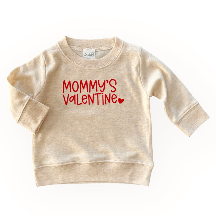 Neutral beige baby and toddler sweatshirt with 'Mommy's Valentine' in bold red lettering and a heart detail. A cozy and adorable Valentine's Day outfit for little ones.