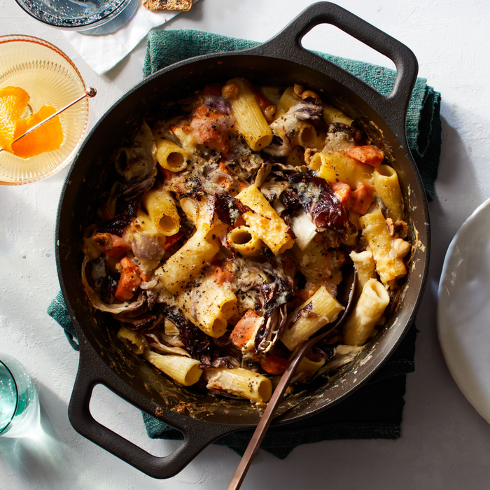 Baked rigatoni in the No.8 Field Cast Iron Dutch Oven with a wooden spoon, overhead view