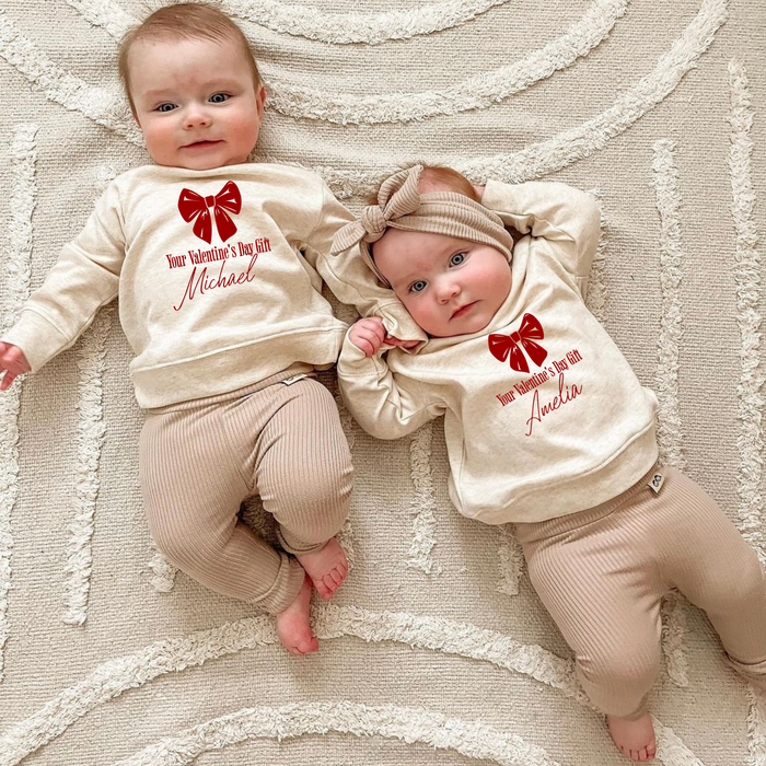 Matching Valentine's Day baby sweatshirts for siblings - Custom names and red bow design. Ideal Valentine's Day photoshoot outfits!