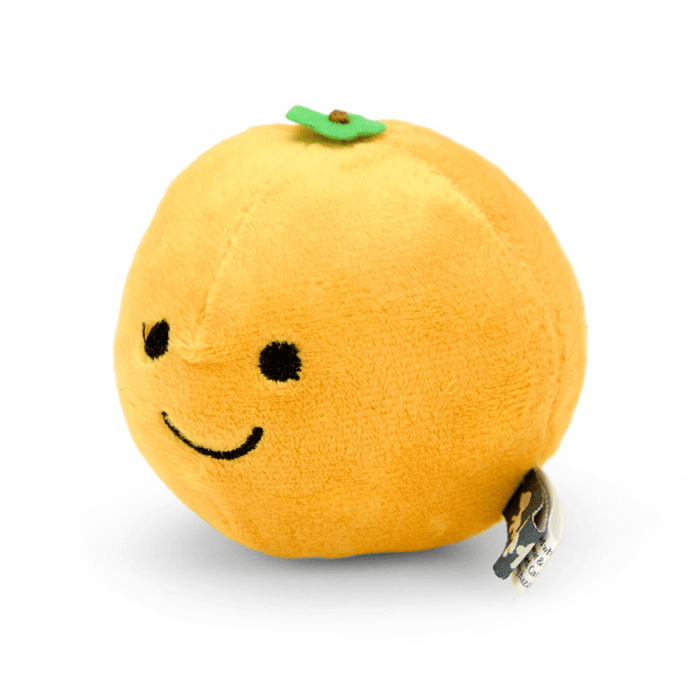Side view of orange fruit plush toy with green leaf detail and a smiley face.