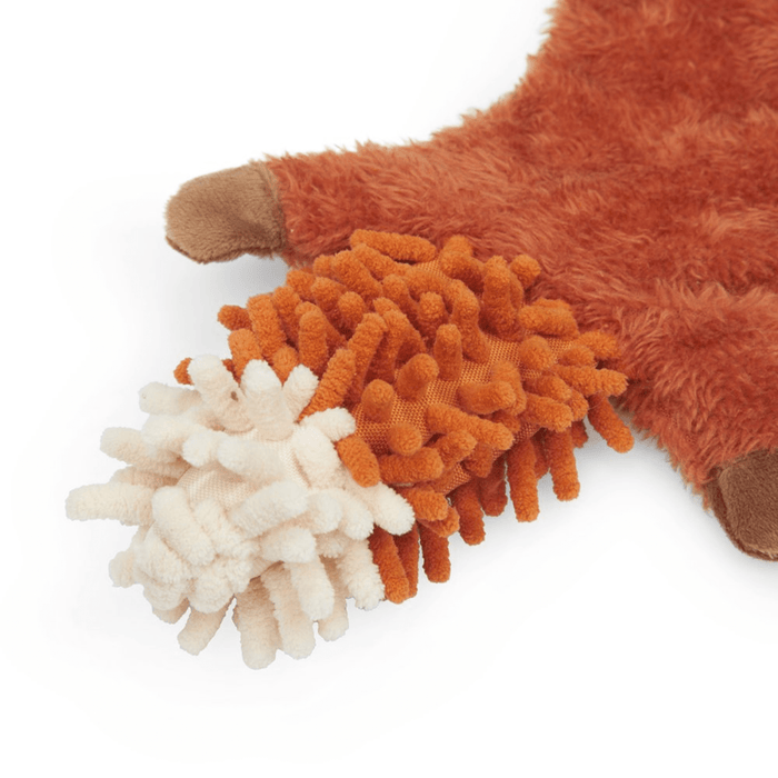 Close up of squirrel dog toy's tail made out of orange microfibre with a white tip on a white background.