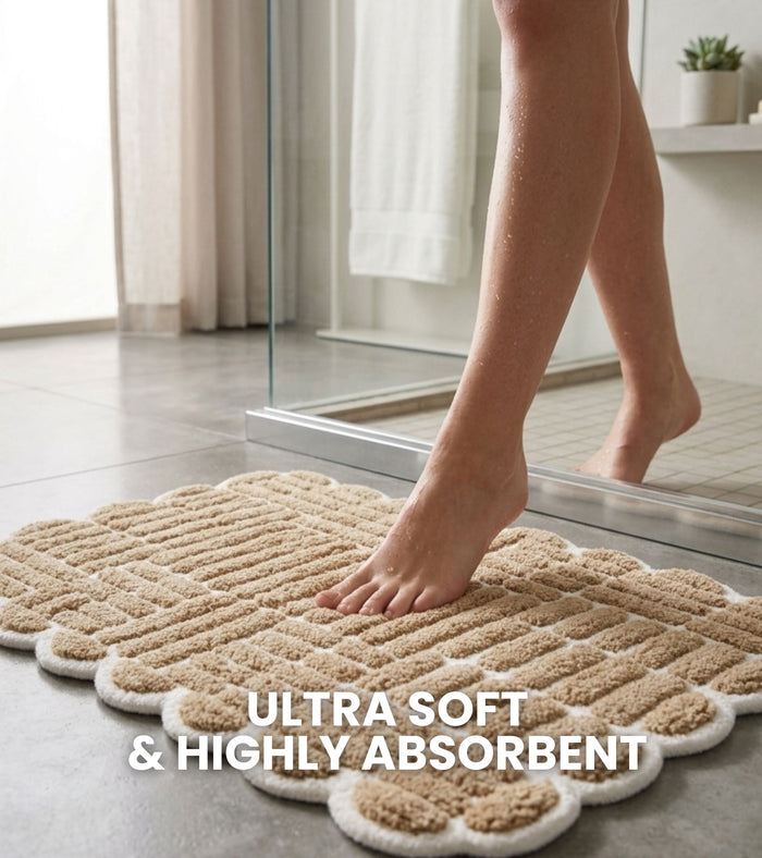 Beige bath mat with raised loop grid and scalloped edges for shower floor use.