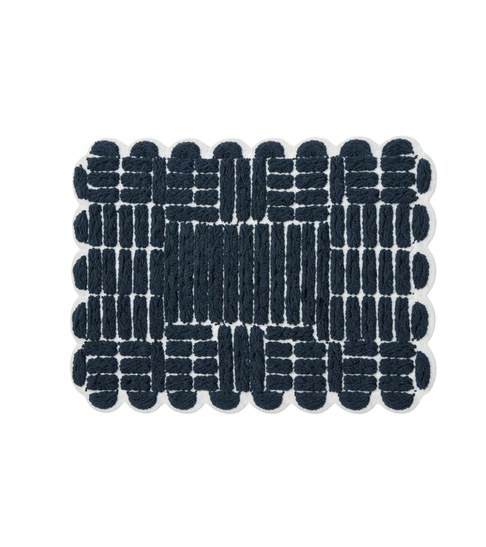 Navy bath mat with looped grid pattern and scalloped edges for non-slip bathroom floors.