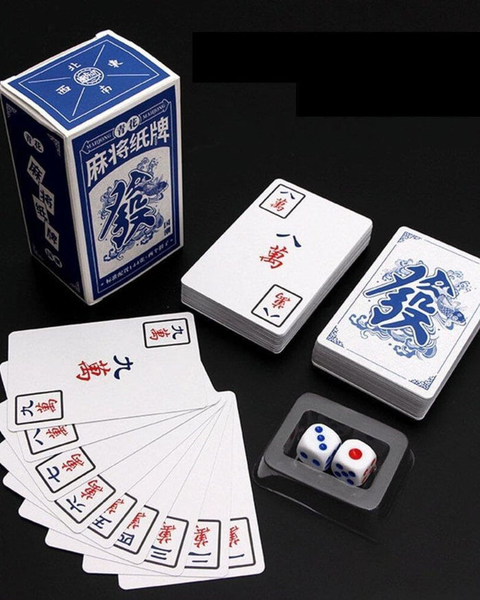 Mahjong playing cards with blue box, stacked cards, and two dice in a tray
