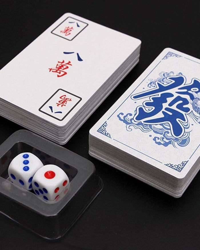Two stacked decks of mahjong playing cards with dice in a plastic holder