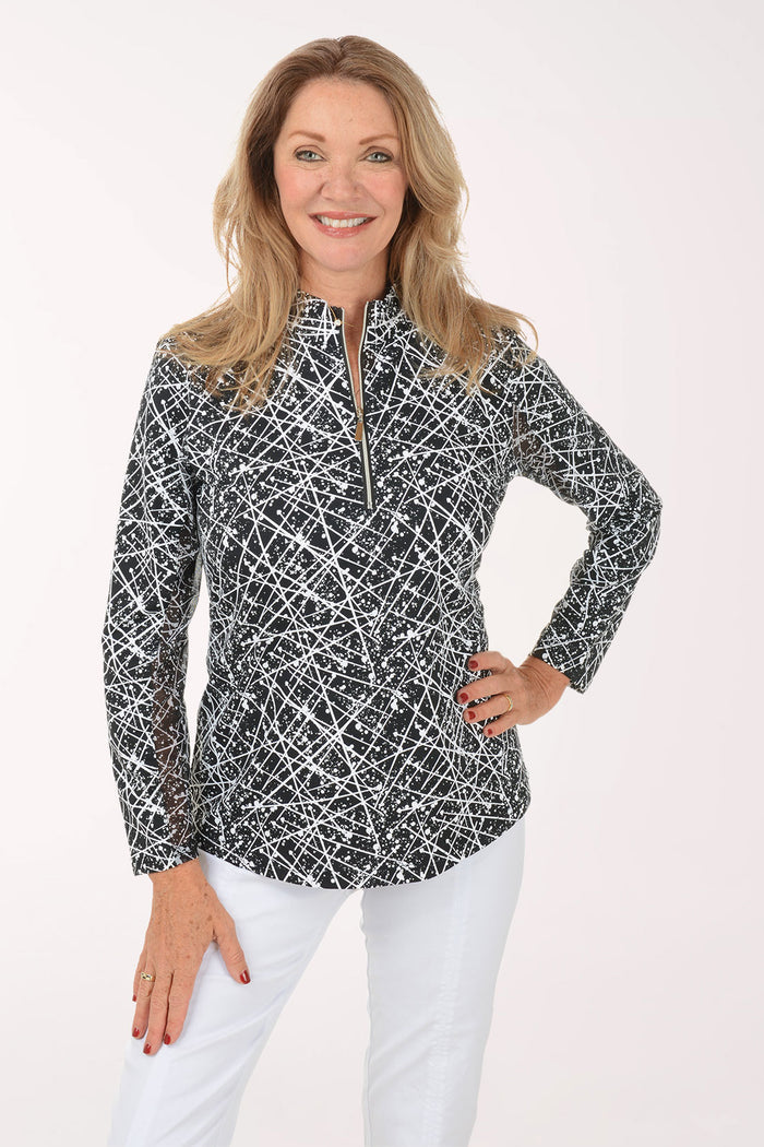 Woman wearing a black and white patterned long-sleeve top on a white background