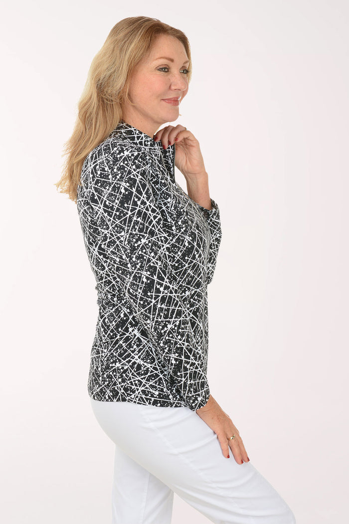 Woman wearing a black and white patterned long-sleeve top on a white background