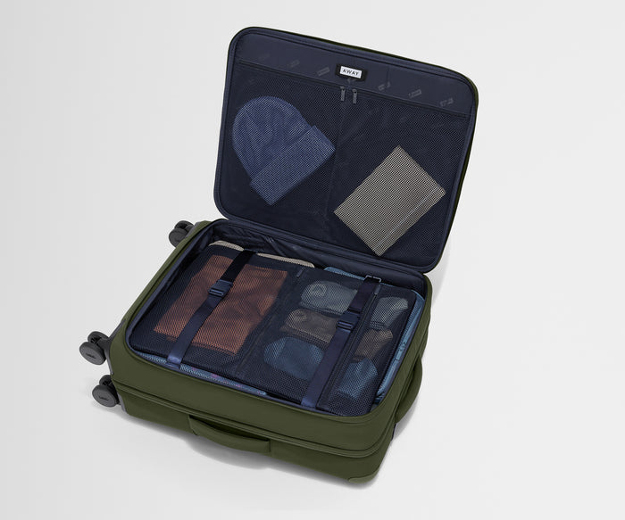 The Softside Medium suitcase in Olive Green shown open on its side and packed with Away's packing organizers to show capacity and the interior compression system, designed to help you pack more in
//
Our patented interior compression system allows you to stay more organized. Paired with The Insider Packing Cubes.