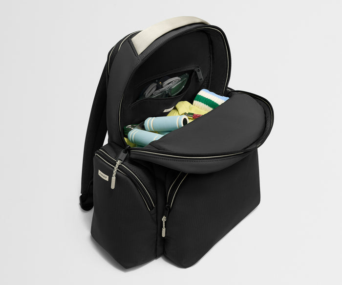 Black backpack with open compartment showing rolled-up items on a light gray background