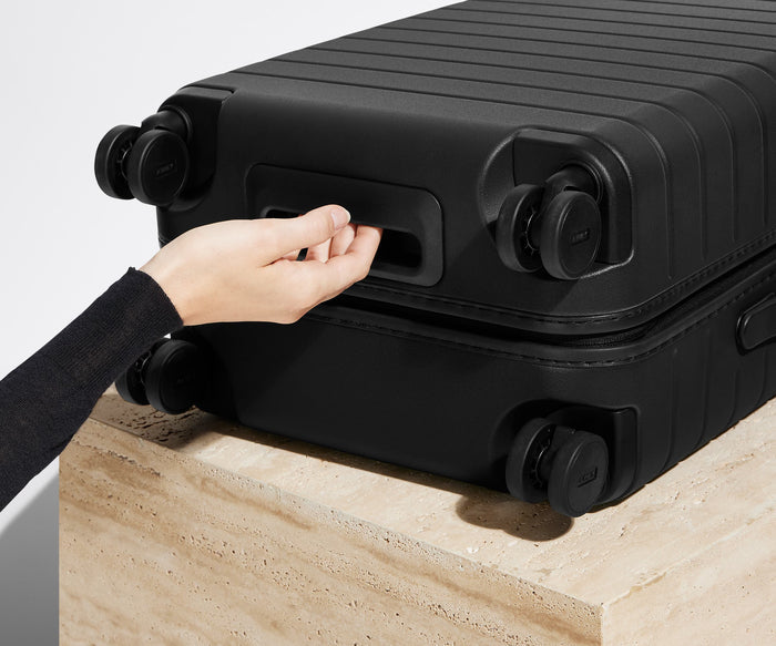 The Bigger Carry-On suitcase in Jet Black shown from below highlighting the underside grab handle
// 
Underside grab handle that makes it easier to lift and carry your suitcase.