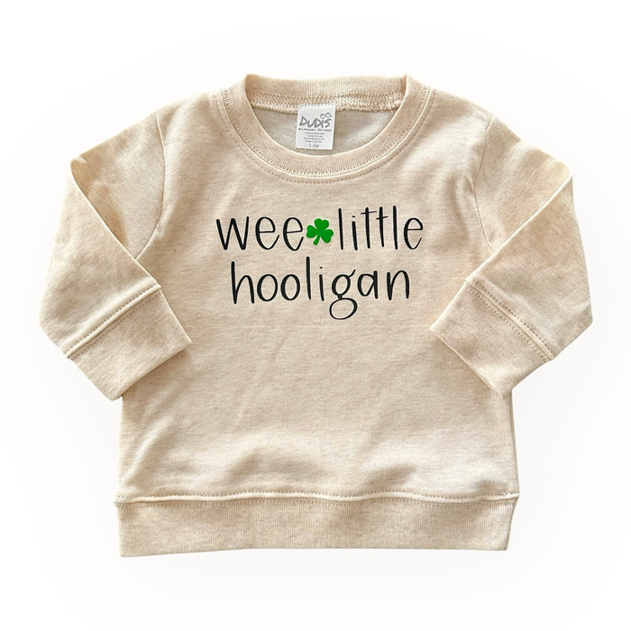 Adorable 'Wee Little Hooligan' cream pullover for babies and toddlers, featuring a playful St. Patrick's Day shamrock design. Soft, cozy, and perfect for festive celebrations or everyday wear. Made for comfort and style!