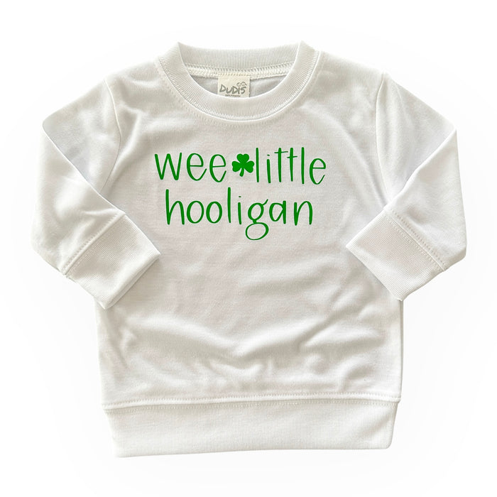 White 'Wee Little Hooligan' pullover for babies and toddlers, featuring a playful green shamrock design. Perfect for St. Patrick's Day celebrations or everyday wear. Soft, cozy, and made for little ones with comfort in mind.
