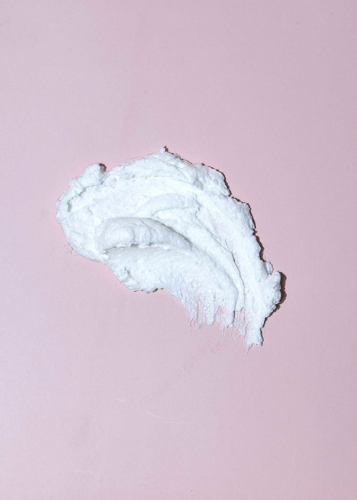 Whip Scrub | Latika cream texture on a soft pink background, showcasing a rich, airy consistency ideal for skincare and body care routines.