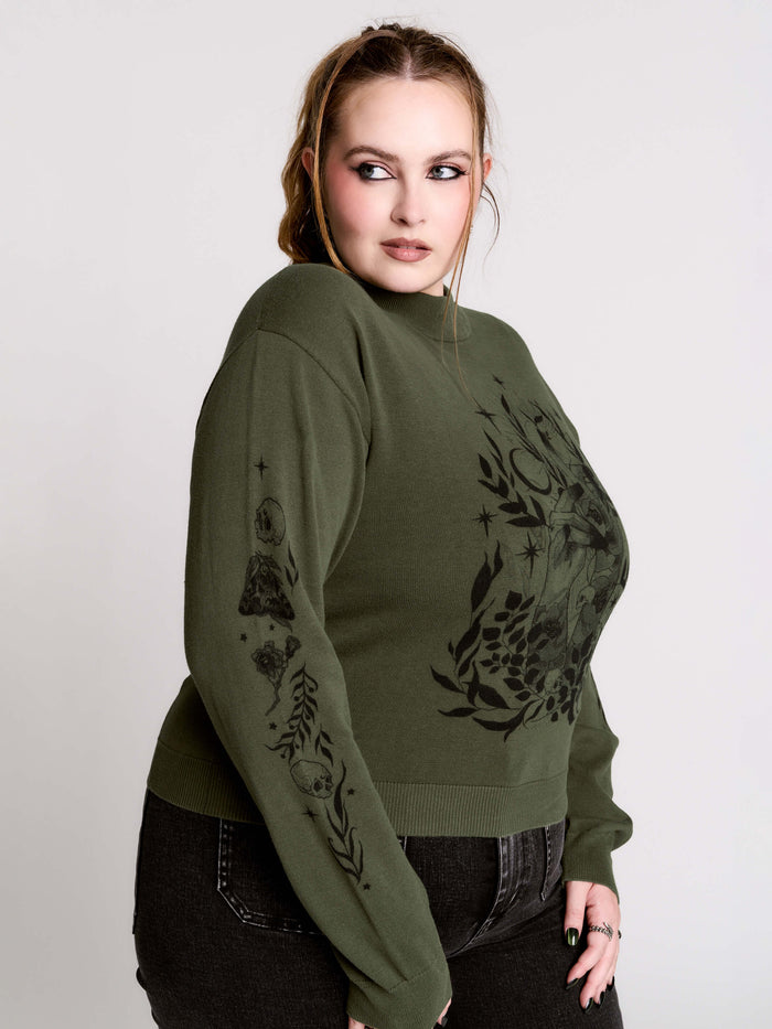 an olive green mock-neck sweater featuring a black gothic graphic